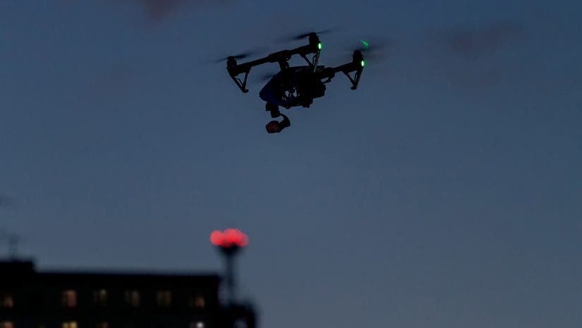 uas night operations drone flying at night over buildings in dark sky