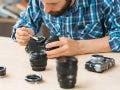 man cleaning camera sensor and lenses with brush and