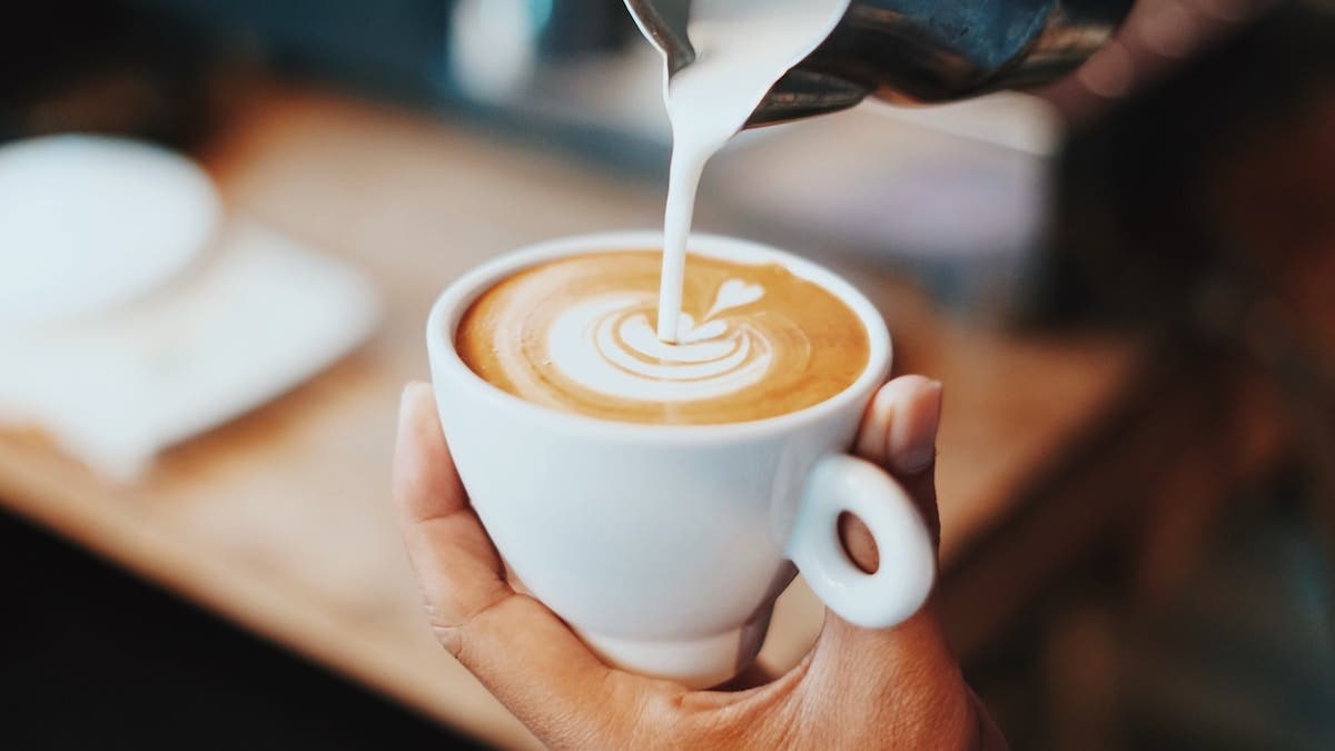 milk poured into coffee cup