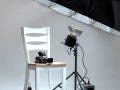 chair and camera posed in photo studio with umbrella