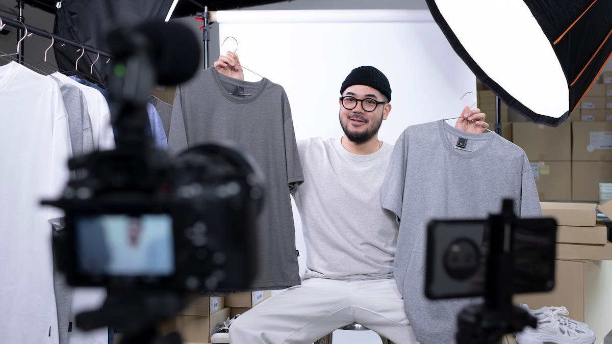 Young attractive Asian man blogger or vlogger looking at camera reviewing product. Modern businessman using social media for marketing. Business online influencer on social media concept.