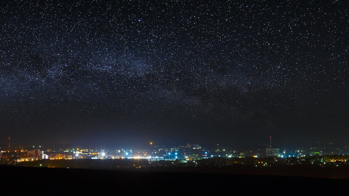 Panoramic view of the starry night sky above the city.