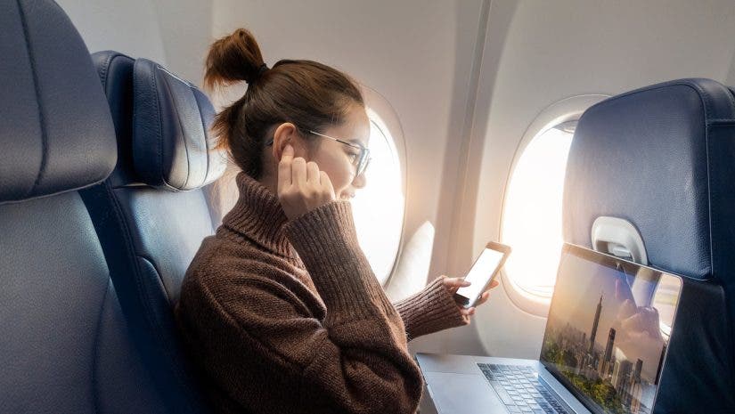 Beautiful Asian woman is working with laptop in airplane