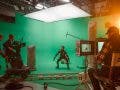 In the Big Film Studio Professional Crew Shooting Blockbuster Movie. Director Commands Cameraman to Start shooting Green Screen CGI Scene with Actor Wearing Motion Capture Suit and Head Rig