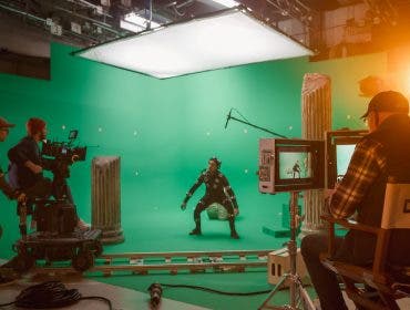 In the Big Film Studio Professional Crew Shooting Blockbuster Movie. Director Commands Cameraman to Start shooting Green Screen CGI Scene with Actor Wearing Motion Capture Suit and Head Rig