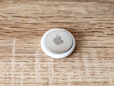 Apple AirTag tag on wooden surface for tracing lost items with copyspace on both sides