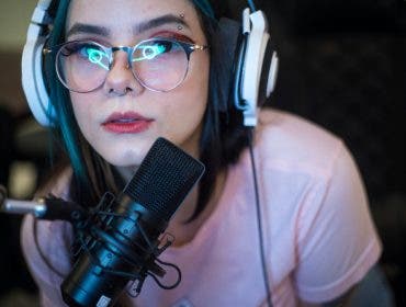 Young woman with headphones and microphone live streaming