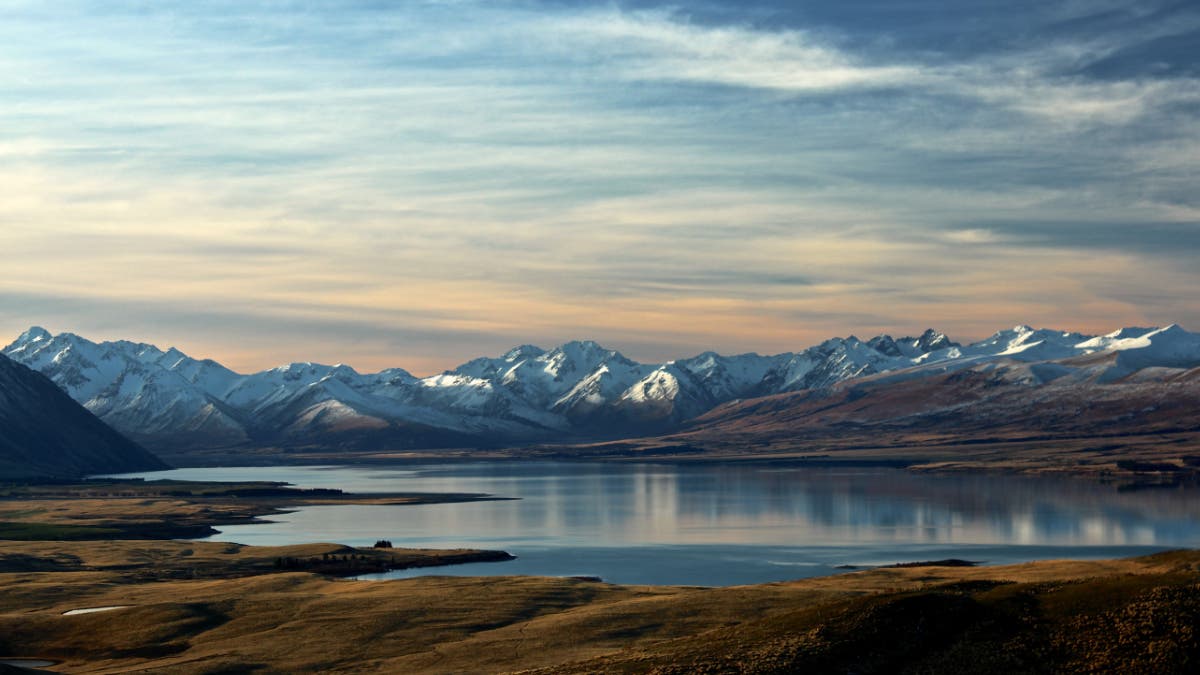 Lake Tekapo New Zealand with snowy mountains in the background.