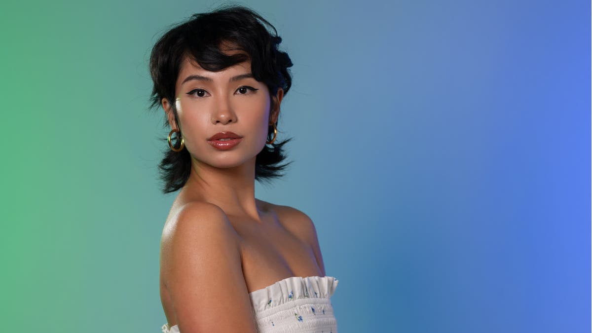 Female model in front of a blue green background lit evenly with flash and V-Flats