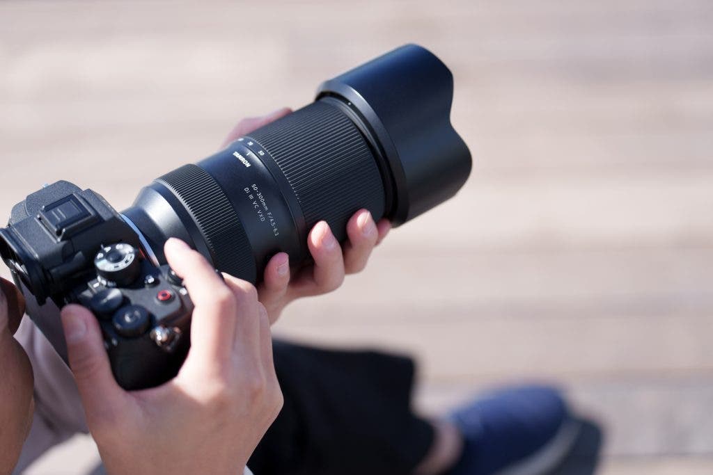 person holding the new TAMRON 50-300mm F/4.5-6.3 Lens