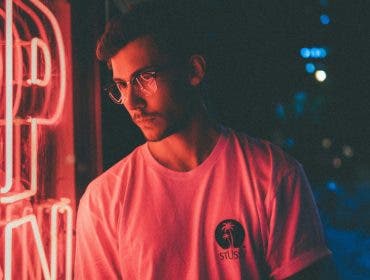 Man is light by the ambient lighting of a neon sigh