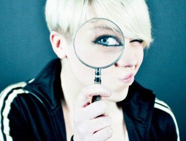 Female looking through a magnifying glass