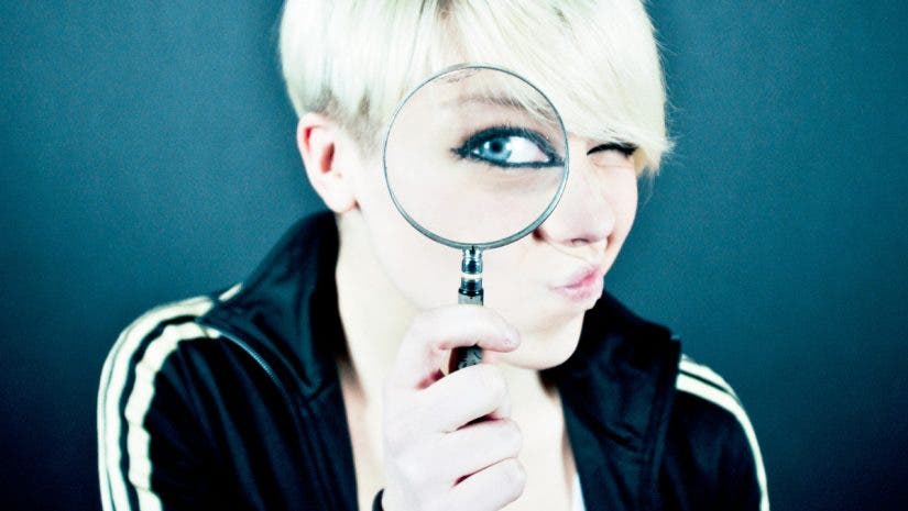 Female looking through a magnifying glass