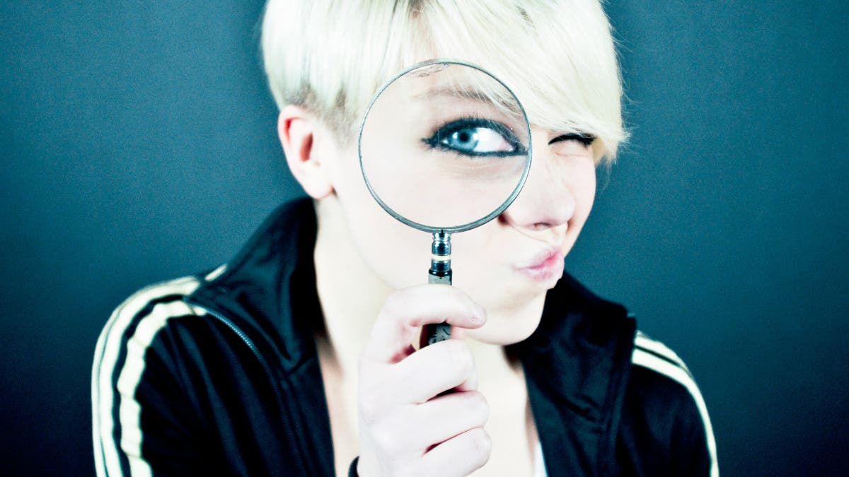 Female looking through a magnifying glass