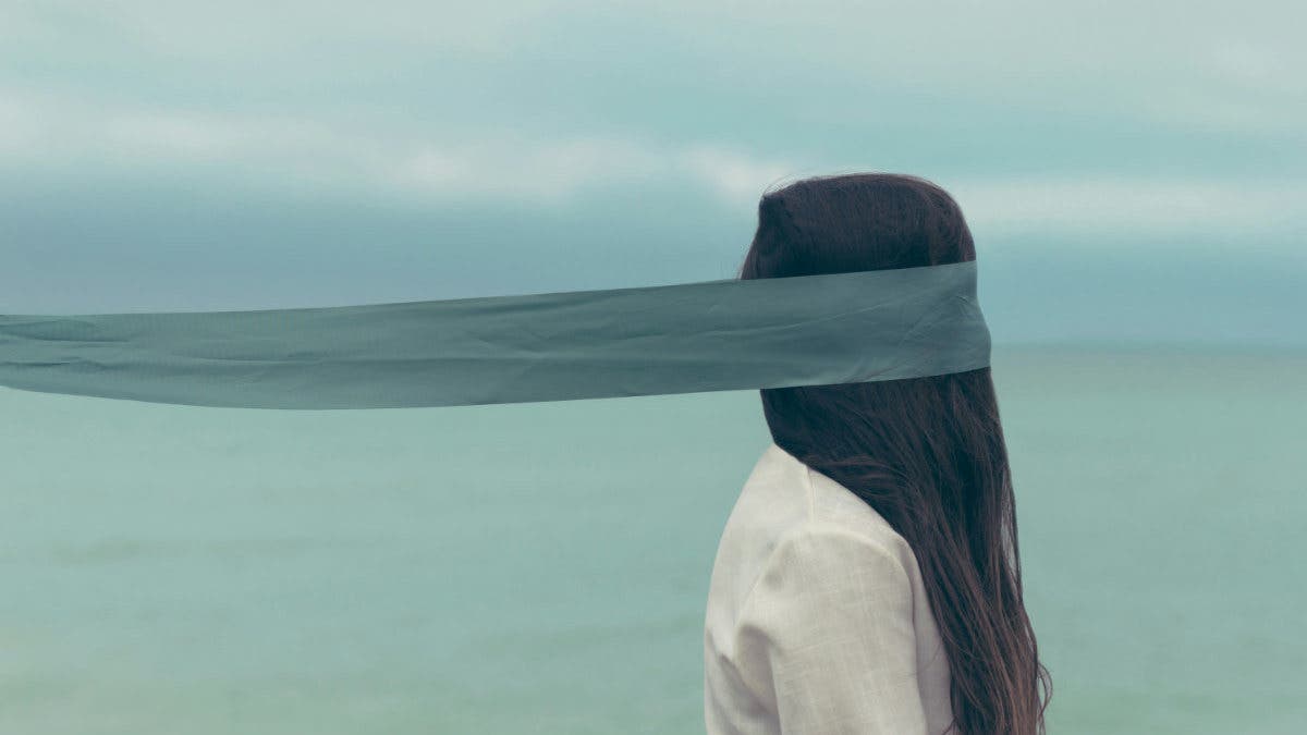 Portrait of a woman with a scarf, the scarf seems to blend into the horizon - the effect is surreal