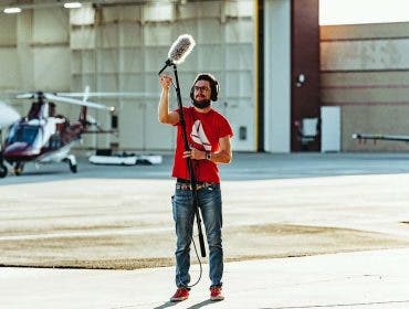Man holding a boom microphone for video