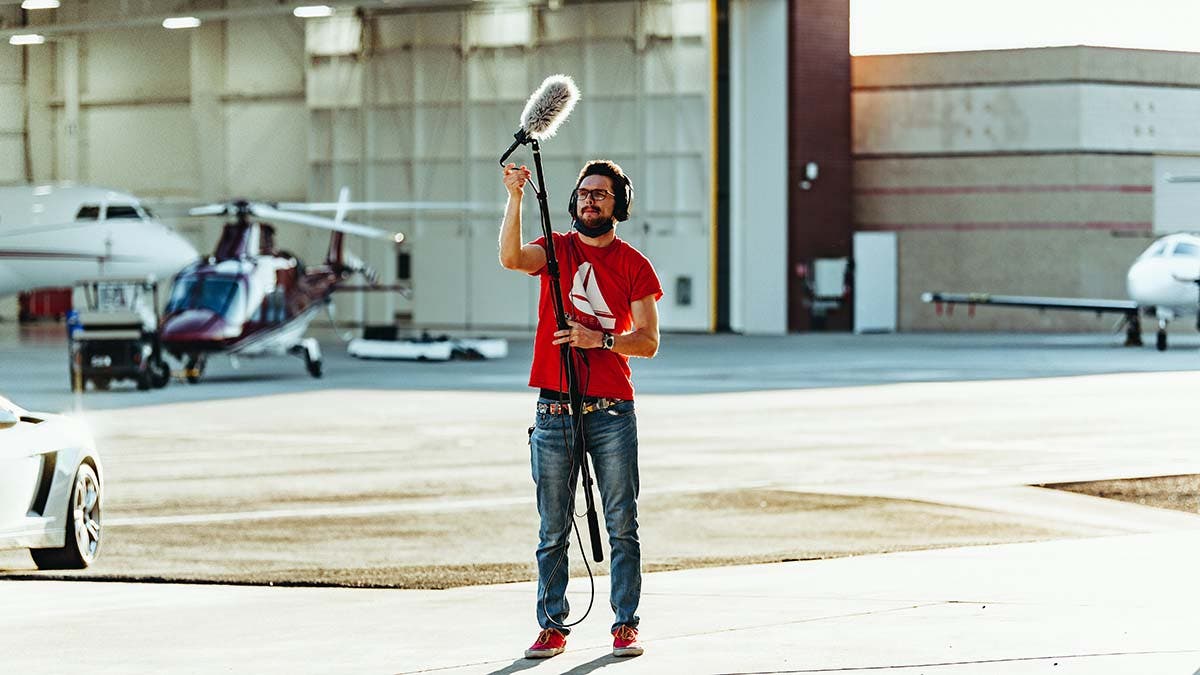 Man holding a boom microphone for video