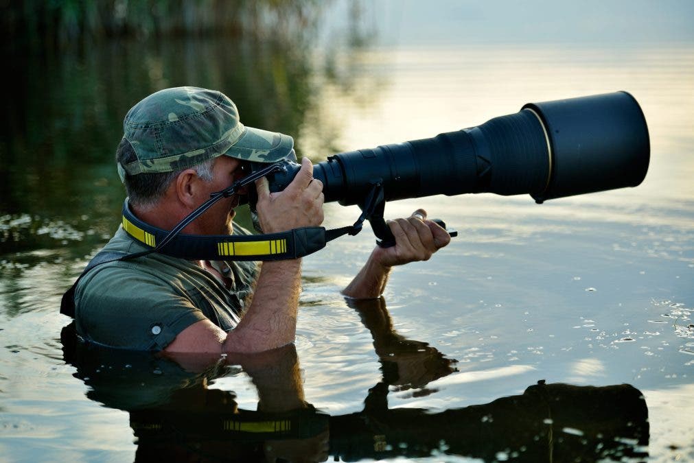 Wildlife photographer holding one of the best lenses for wildlife photography