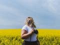 Female photographer looks back on field while holding camera