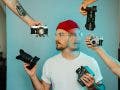 man holding many cameras