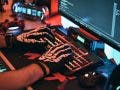 Man uses gaming keyboard with skeleton gloves