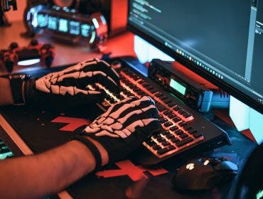 Man uses gaming keyboard with skeleton gloves