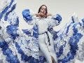 Woman in amazing flying dress with blue and white waves and mask. Drawing and ruffles on clothes. Fluttering fabric