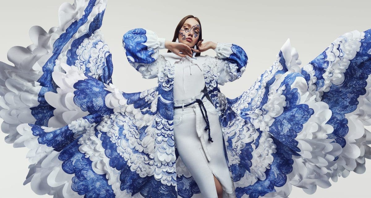 Woman in amazing flying dress with blue and white waves and mask. Drawing and ruffles on clothes. Fluttering fabric