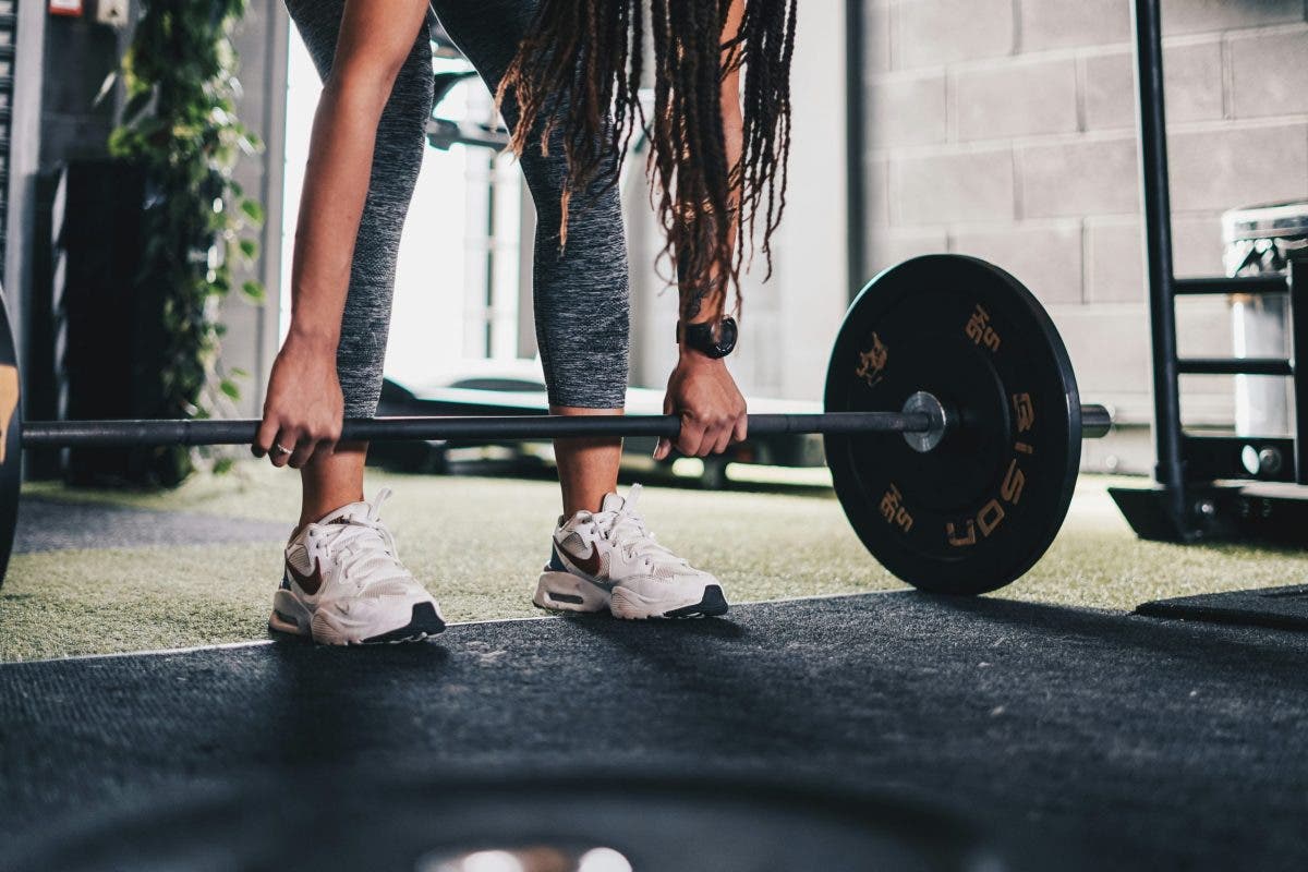 woman wearing a fitness tracker at the gym doing strength training