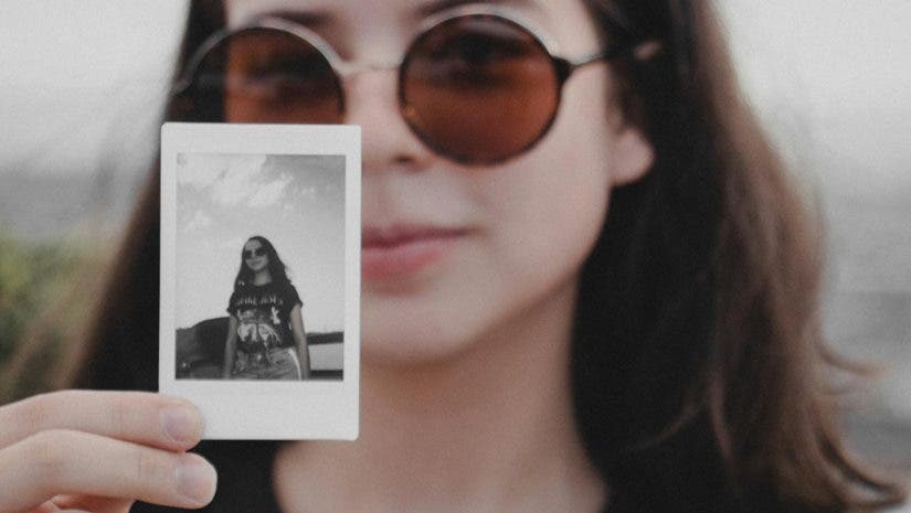 Woman holding image from instant camera