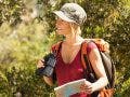 outdoors adventure - aunt- woman hiking and holding binoculars and map.