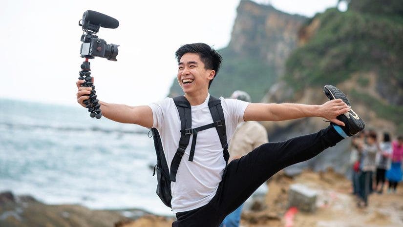 Vlogger holds and smile with his camera