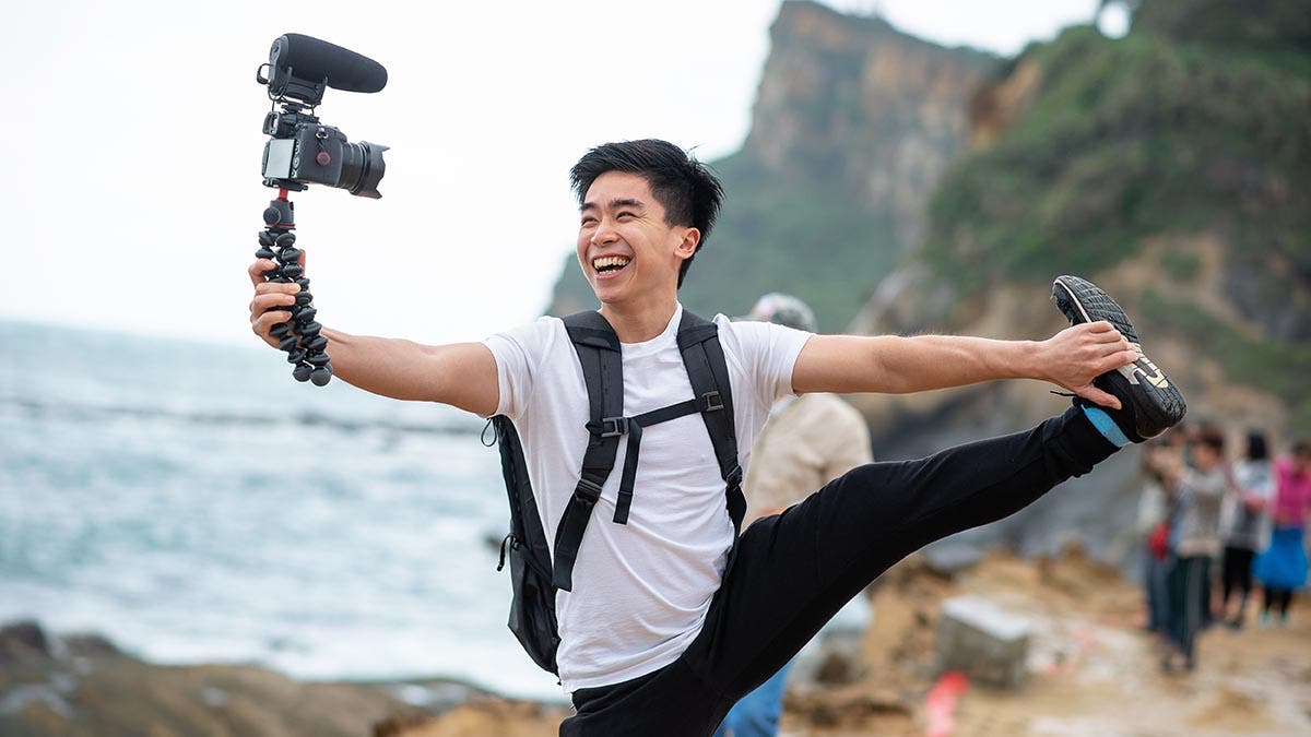 Vlogger holds and smile with his camera