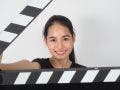 Young woman - Aspiring filmmaker -holding black clapper board or movie slate or clapperboard .it use in video production ,film, movie,cinema industry on white background.