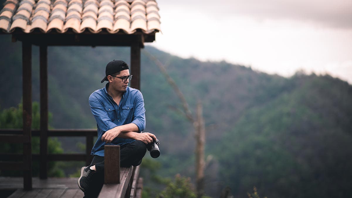 person on a mountain taking photos with a Canon EOS Camera
