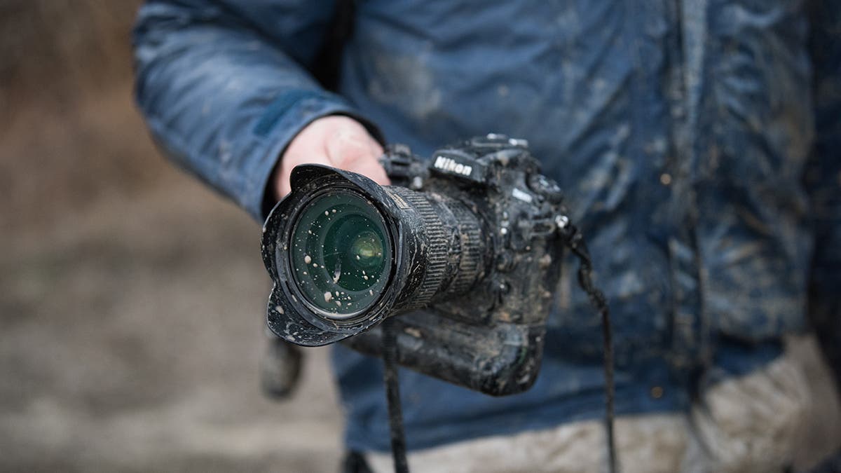 Nikon shooter in the field - Nikon covered with mud but still working