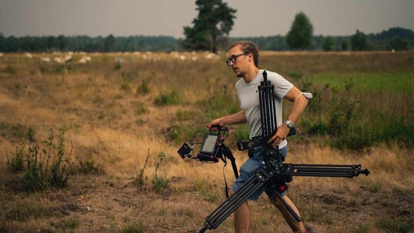 a man carrying gear as a camera assistant