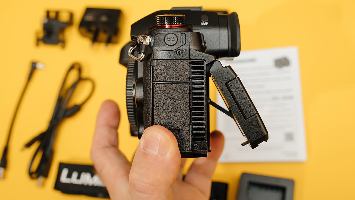 Paris, France - Nov 20, 2022: POV male hand holding new Panasonic Lumix DMC-GH6 Micro Four Thirds System digital still video camera with 5k 10 bit Video recording - fan tilt screen