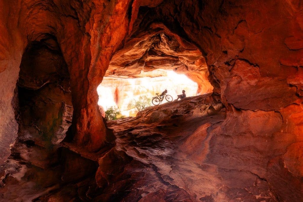 Cyclist in a Cave.jpg “Silent Reflections: A Cyclist’s Rest in the Shadows of Africa”