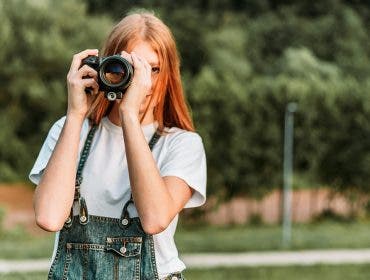 Ginger teen, girl taking photos with camera.