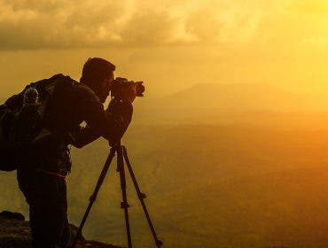 A male photographer travels and shoots landscapes at sunset Landscape photography gear
