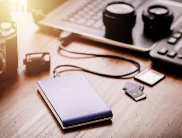 Closeup external hard drive on wooden desktop. Working with external hard drive. Solid State Drive