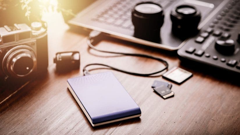 Closeup external hard drive on wooden desktop. Working with external hard drive. Solid State Drive