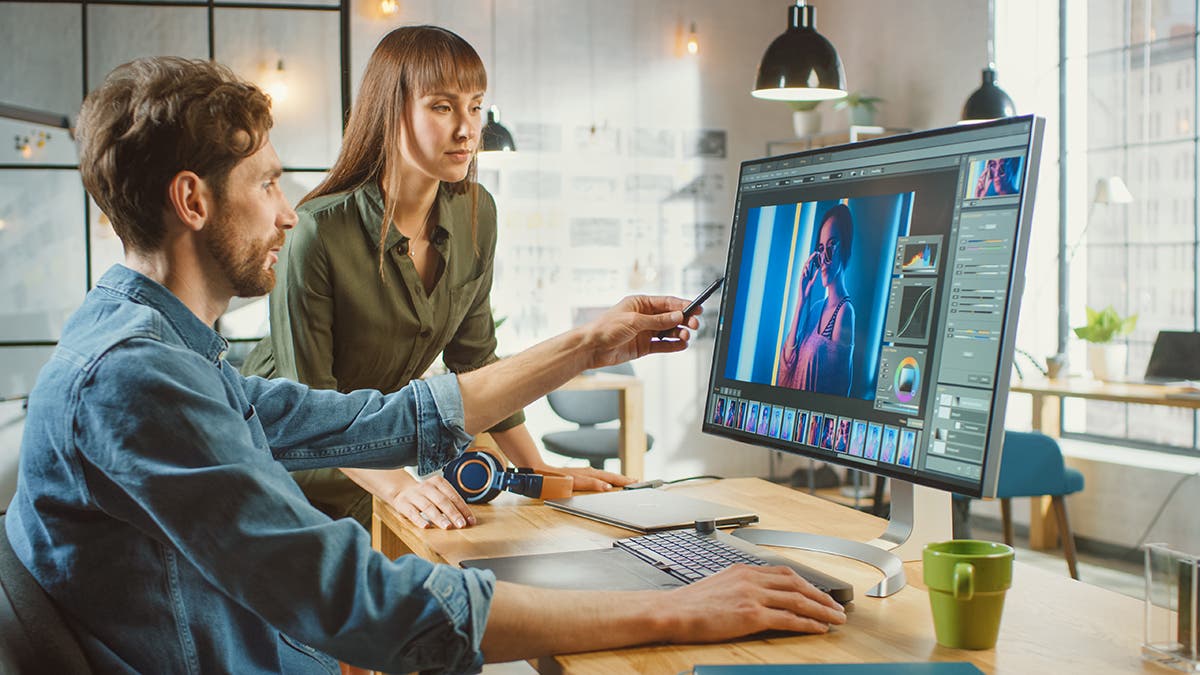Female Art Director Consults Designer Colleague working on a Portrait using a Photo Editing Software. By Gorodenkoff on Adobe Stock