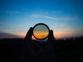 Hand holding filter lens camera, sunset, mountain, landscape
