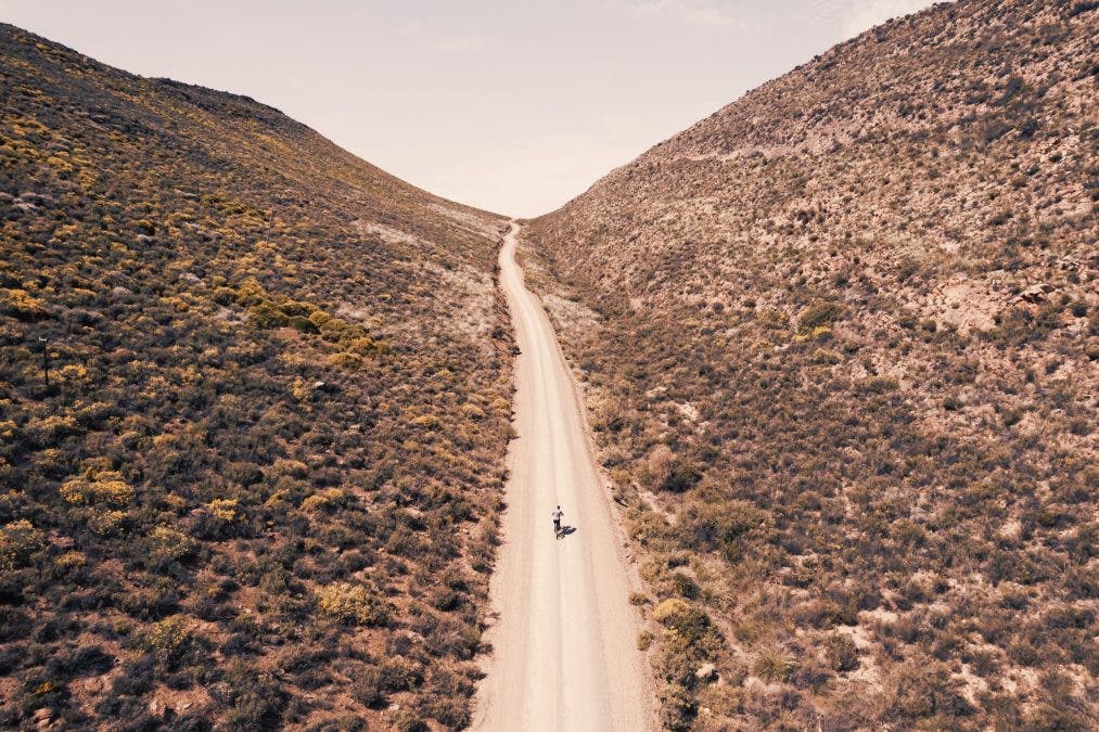 Endless roads, towering mountains, and one lone cyclist—captured from a perspective only a drone can reveal