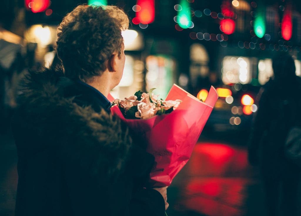 a man holding flowers for his girlfriend