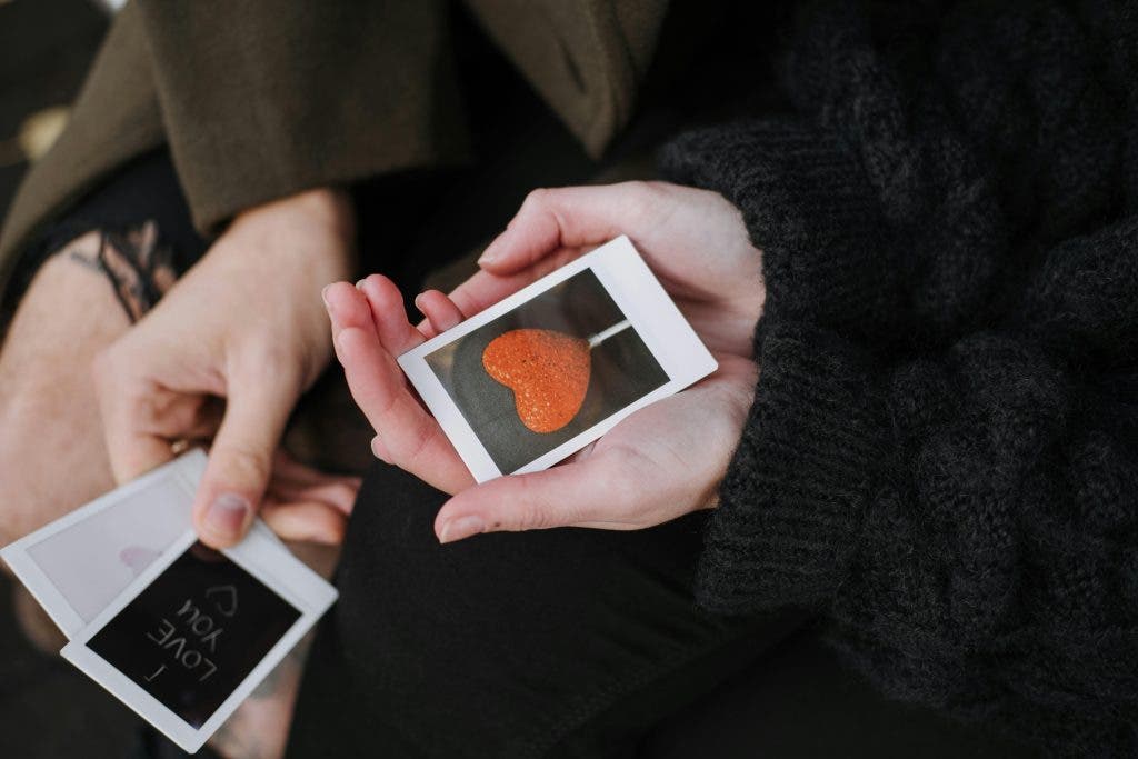 two people holding romantic polaroids
