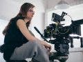 A woman is a cameraman behind a camera on a crane. Filming a mov