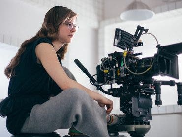 A woman is a cameraman behind a camera on a crane. Filming a mov